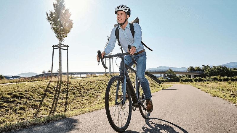 stilvoll gekleideter Mann fährt auf Fahrrad