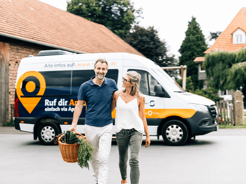 Mann mit Korb und Frau entfernen sich vom Auto im Hintergrund